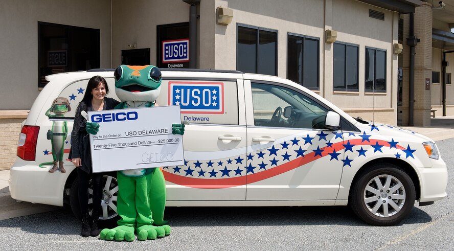 Anne Scharp, GEICO field representative for Delaware, left, presents a $25,000 donation to United Service Organizations Delaware, April 22, 2015, at the USO Delaware Community Center on Dover Air Force Base, Del. The GEICO corporate donation will be used to support programs and services for service men, women and their families. Holding the check along with Scharp is the GEICO Gecko, Terri Hansen, USO Delaware volunteer, right. (U.S.  Air Force photo/Roland Balik)
