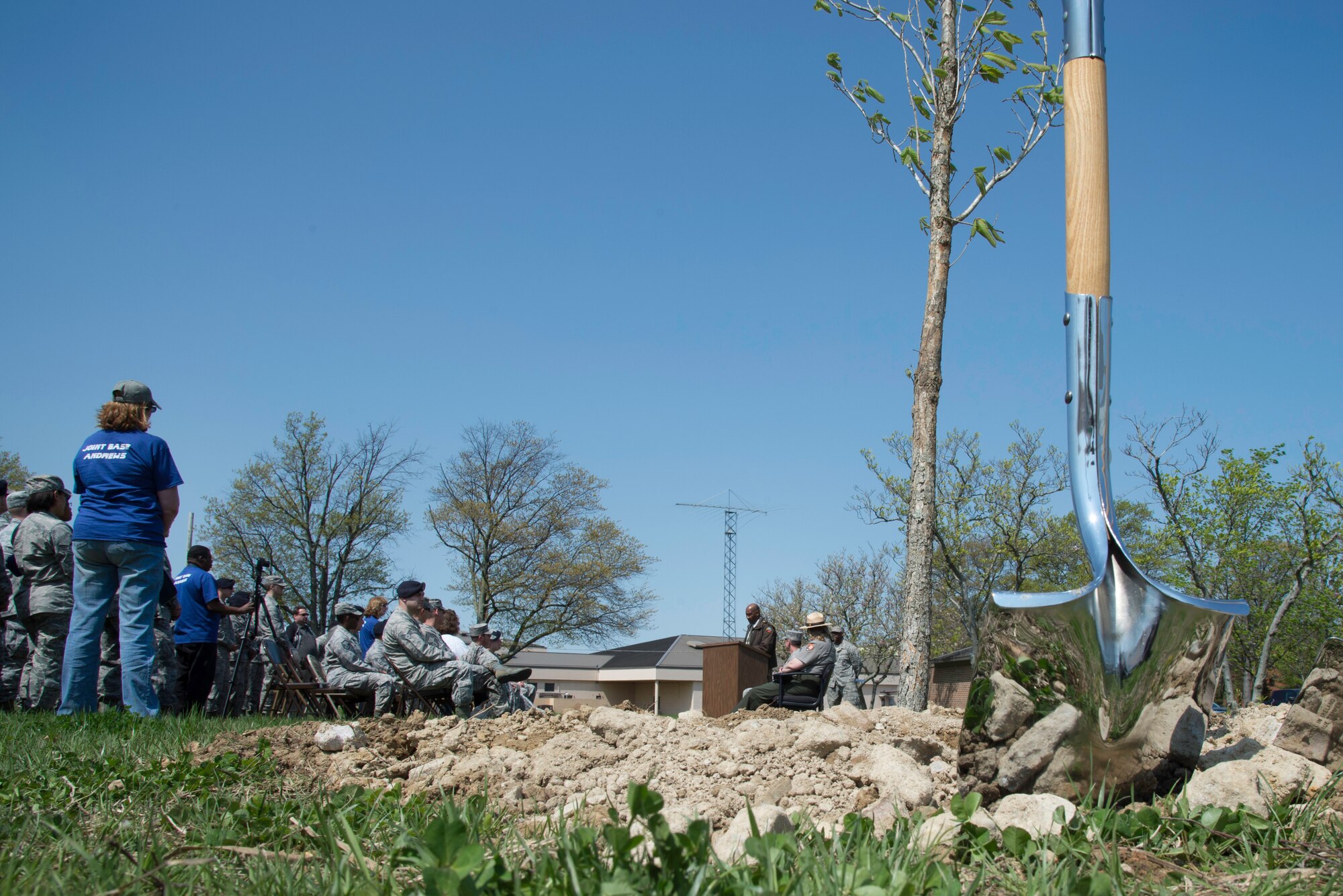 A ceremonial shovel sticks into the ground while Horace Henry, Maryland’s Forestry Service southern region urban and community forestry coordinator, speaks to a crowd during an Earth Day and Arbor Day ceremony outside Building 1657 at Joint Base Andrews, Md., April 22, 2015. Henry was one of two speakers at the ceremony that spoke about the importance of protecting the environment. (U.S. Air Force photo/Airman 1st Class Philip Bryant)