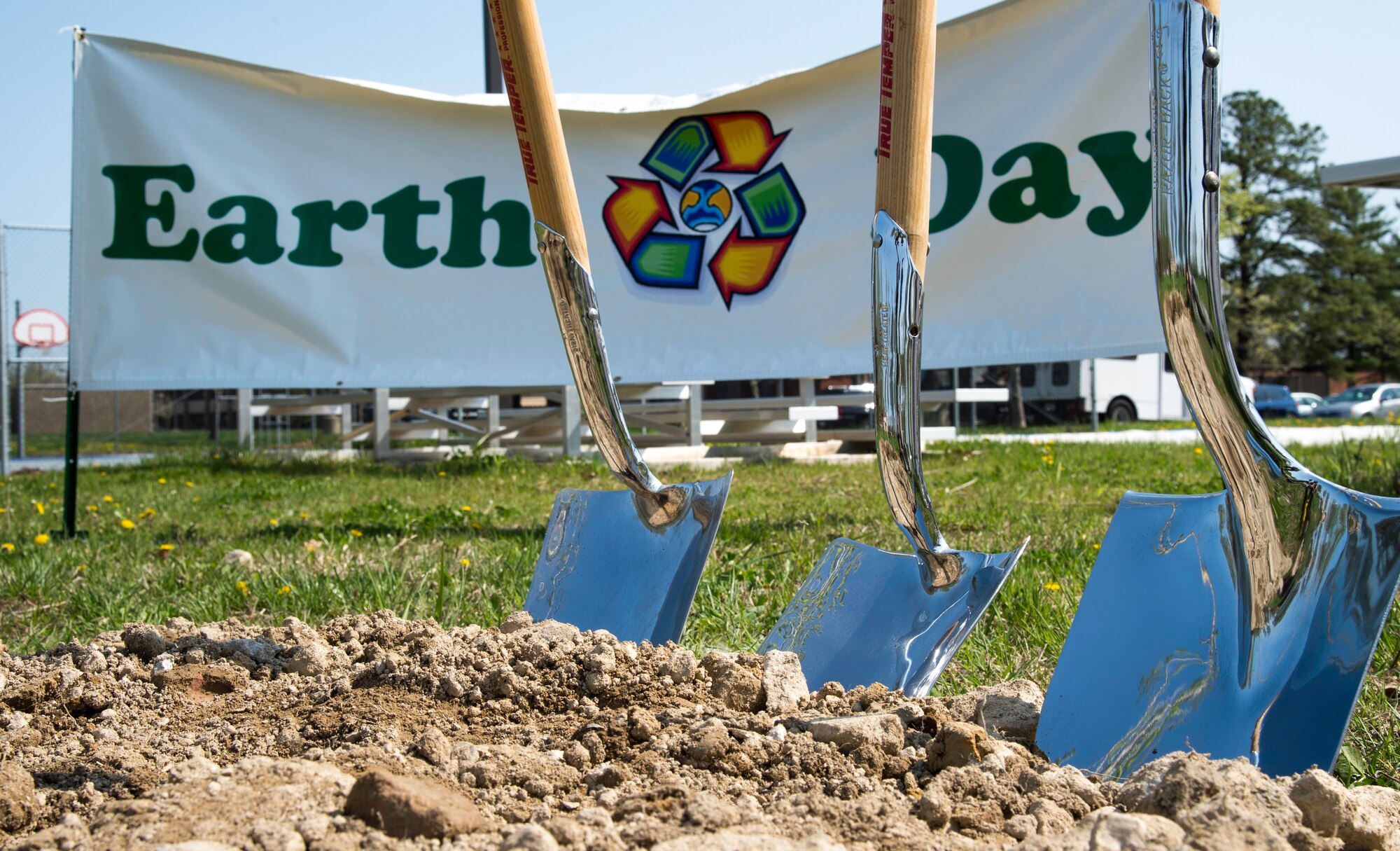 Three ceremonial shovels stick into the ground before an Earth Day and Arbor Day ceremony outside Building 1657 at Joint Base Andrews, Md., April 22, 2015. The ceremony included two local environmental representatives speaking about the importance of protecting the environment and the planting of three white oak trees. (U.S. Air Force photo/Airman 1st Class Philip Bryant)