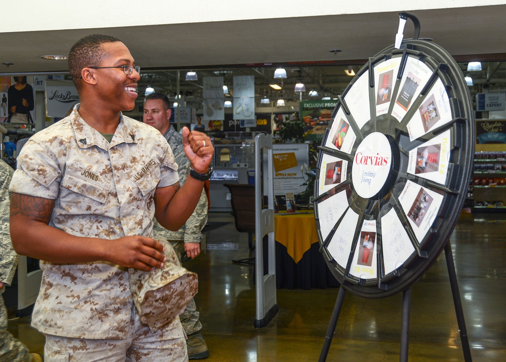 Marine Cpl. Deshunte Jones, VMX-22, spins to win at the Corvias Military Housing booth April 22. When the wheel stopped, Jones won a flower kit for his wife in honor of Earth Day. (U.S. Air Force photo by Rebecca Amber)