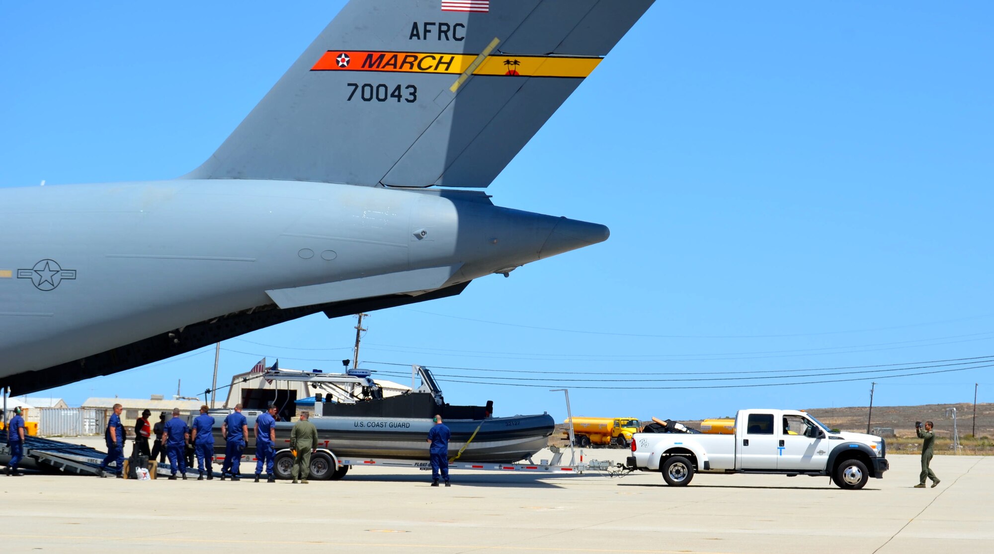 A U.S. Coast Guard Transportable Port Security Boat and truck are ready to be unloaded from a C-17 Globemaster III aircraft from March Air Reserve Base, California, April 16, 2015 at Naval Auxiliary Landing Field on San Clemente Island, California. The U.S. Coast Guard was one of several participants in the annual Patriot Hook Exercise by the Air Force Reserve Command, which integrates federal agencies with the military, for world-wide mobility and readiness. (U.S. Air Force photo/Capt. Cris Medina)