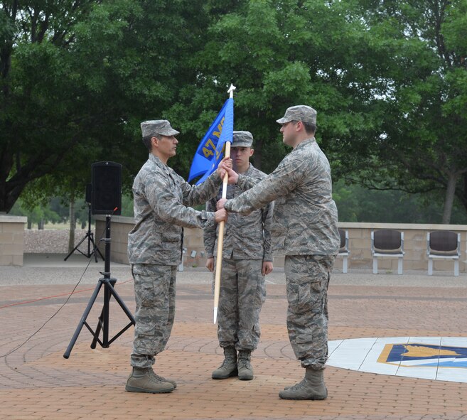 Col. Eric Shafa, left, 47th Mission Support Group commander, passes the 47th Logistics Readiness Flight guidon to Capt. Keith Carson as he assumes command of the LRF on Laughlin Air Force Base, Texas, April 22, 2015.  The assumption of command ceremony is part of a rich tradition that allows units to witness the formal transfer of command from one officer to another. (U.S. Air Force photo by 2nd Lt. Aaron Redfield)