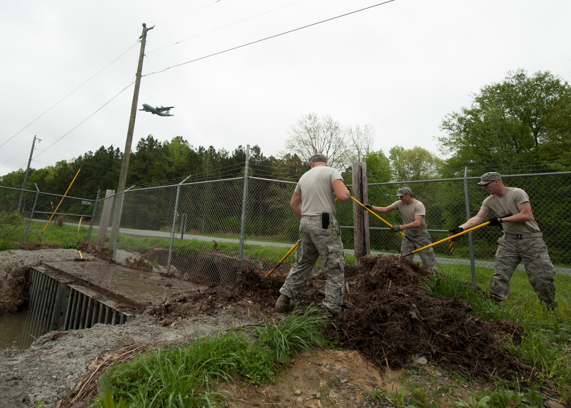 Members from the 19th Civil Engineer Squadron pile debris from a culvert April 13, 2015, at Little Rock Air Force Base, Ark. Constructing and maintaining drainage systems on base are also responsibilities of the “Dirt Boyz”. (U.S. Air Force photo by Airman 1st Class Scott Poe)   