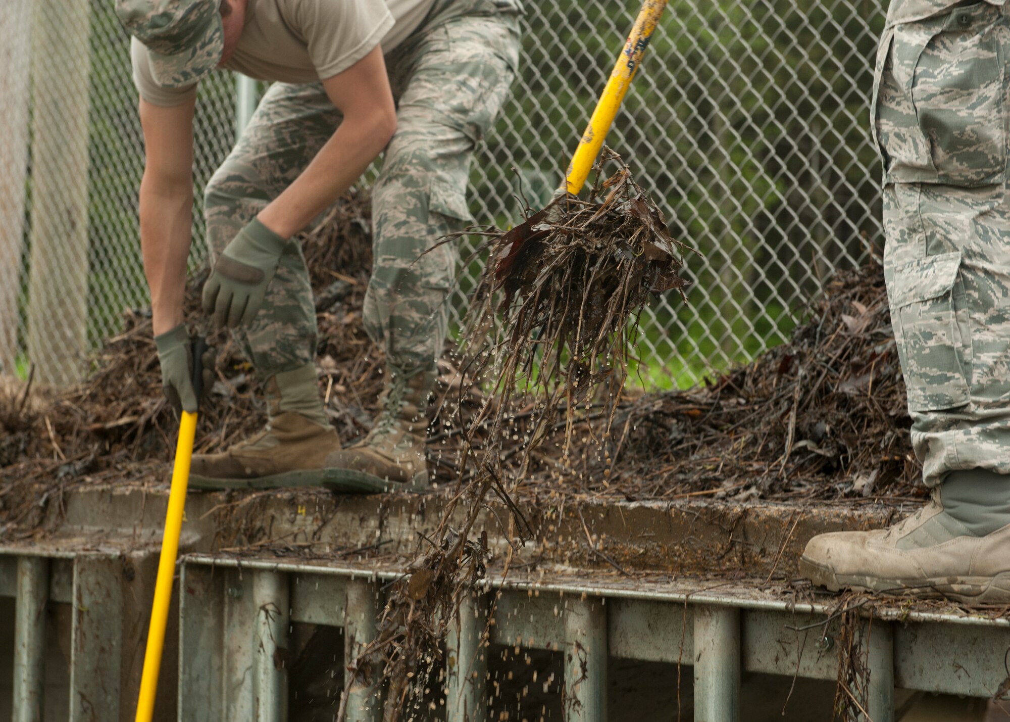 Members from the 19th Civil Engineer Squadron rake debris from a culvert that can slow and clog drainage systems April 13, 2015, at Little Rock Air Force Base, Ark. The Dirt Boyz’s arsenal ranges from shovels and rakes to dozers and excavators. (U.S. Air Force photo by Airman 1st Scott Poe)