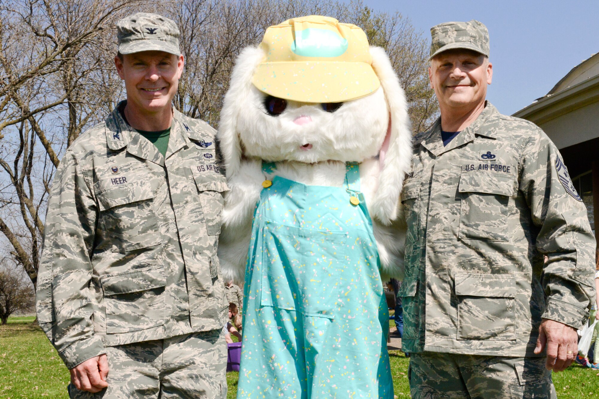 Col. Kevin Heer (left), 132d Wing (132WG), Des Moines, Iowa Commander, and Chief Master Sgt. Timothy Cochran (right), 132WG Command Chief, pose for a photo with the Easter Bunny during the 2015 Annual Easter Egg Hunt held outside of the Dining Facility of the 132WG on Saturday, April 11, 2015.  (U.S. Air National Guard photo by Tech. Sgt. Michael B. McGhee/Released)