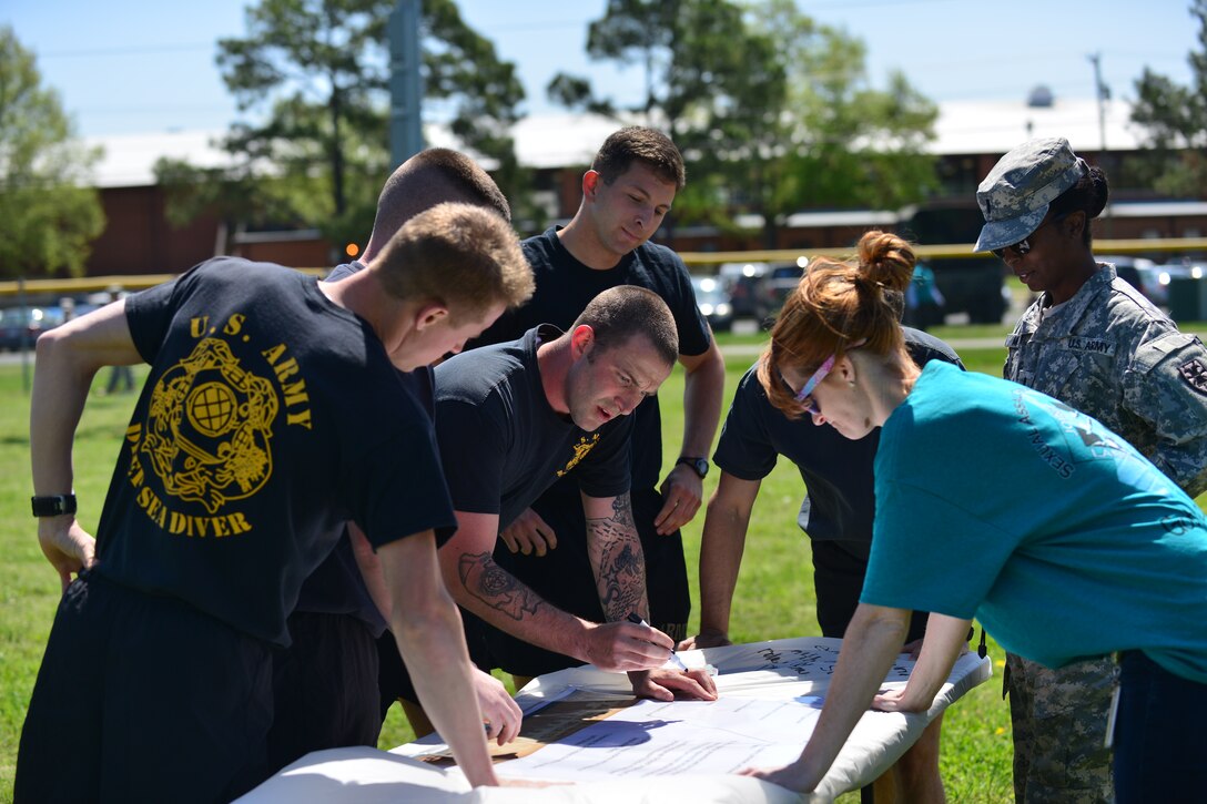 Members of the 20th Engineer Brigade, 30th Engineer Battalion, and 86th Engineer Detachment (Dive) dive team work together to match titles with definitions during the “Carry the Load” competition at Fort Eustis, Va., April 22, 2014. The competition was a part of Sexual Assault Awareness Month, and it emphasized the importance of seeking help and working with others to get through problems as opposed to “carrying the load” alone. (Photo by U.S. Air Force Staff Sgt. Natasha Stannard/Released)