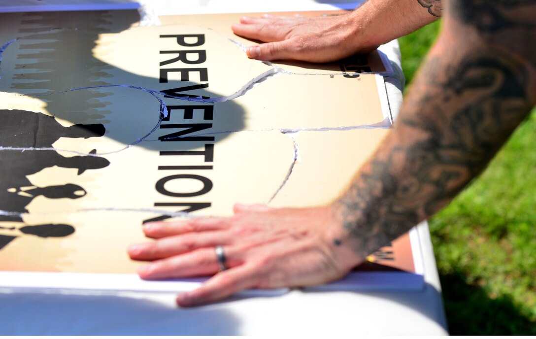 Members of the 20th Engineer Brigade, 30th Engineer Battalion, and 86th Engineer Detachment (Dive) dive team put together a puzzle during the “Carry the Load” competition at Fort Eustis, Va., April 22, 2014. The competition was a part of Sexual Assault Awareness Month, and it highlighted issues victims may encounter that they should not face alone. (Photo by U.S. Air Force Staff Sgt. Natasha Stannard/Released)