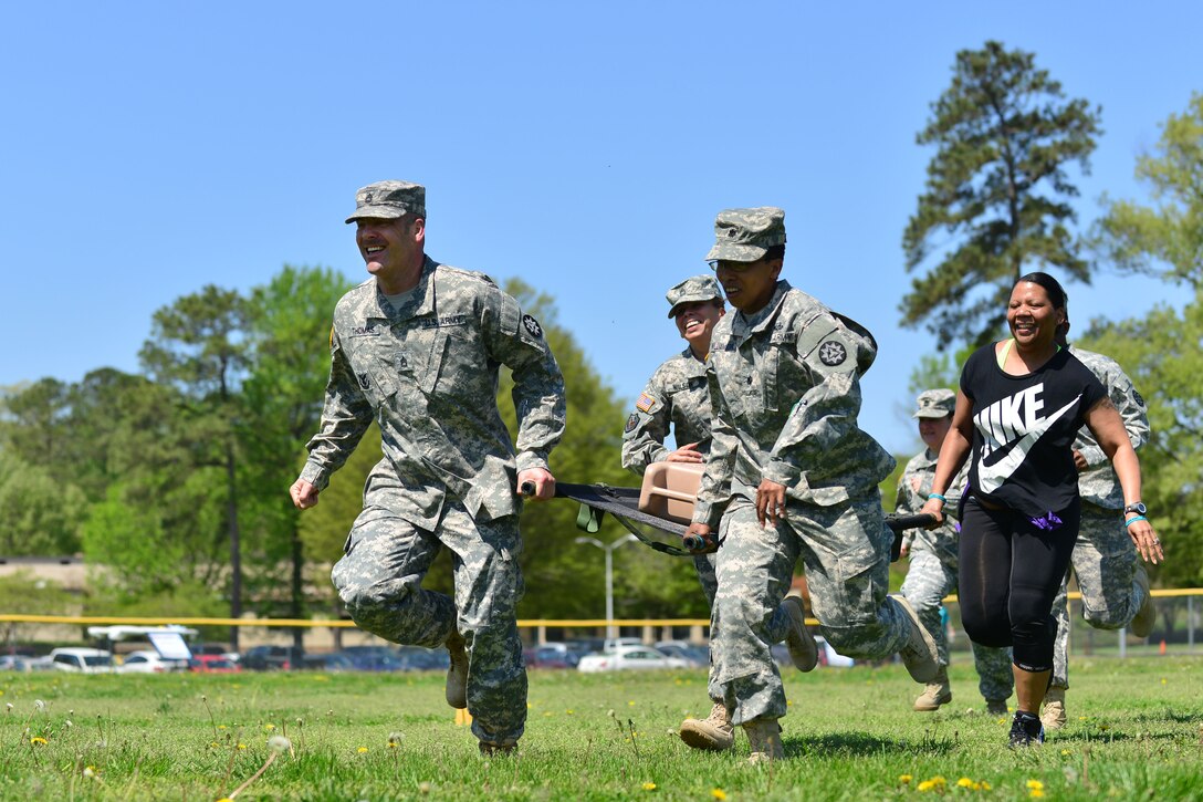Members of the 93rd Signal Brigade race to the finish line during the “Carry the Load” competition at Fort Eustis, Va., April 22, 2014. The competition as was put on to raise awareness for sexual assault prevention and response, and information booths were displayed at the competition to give people more insight. (Photo by U.S. Air Force Staff Sgt. Natasha Stannard/Released)