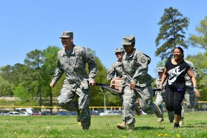 Members of the 93rd Signal Brigade race to the finish line during the “Carry the Load” competition at Fort Eustis, Va., April 22, 2014. The competition as was put on to raise awareness for sexual assault prevention and response, and information booths were displayed at the competition to give people more insight. (Photo by U.S. Air Force Staff Sgt. Natasha Stannard/Released)