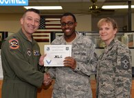 Staff Sgt. Malcolm Williams, center, 47th Force Support Squadron NCO in charge of Assignments and Formal Training, poses with Col. Brian Hastings, 47th Flying Training Wing commander, and Chief Master Sgt. Teresa Clapper, 47th FTW command chief, after accepting the XLer of the Week award here April 15, 2015. The XLer is a weekly award chosen by wing leadership and is presented to those who consistently make outstanding contributions to their unit and Laughlin. (U.S. Air Force photo by Airman 1st Class Ariel D. Delgado)(Released)