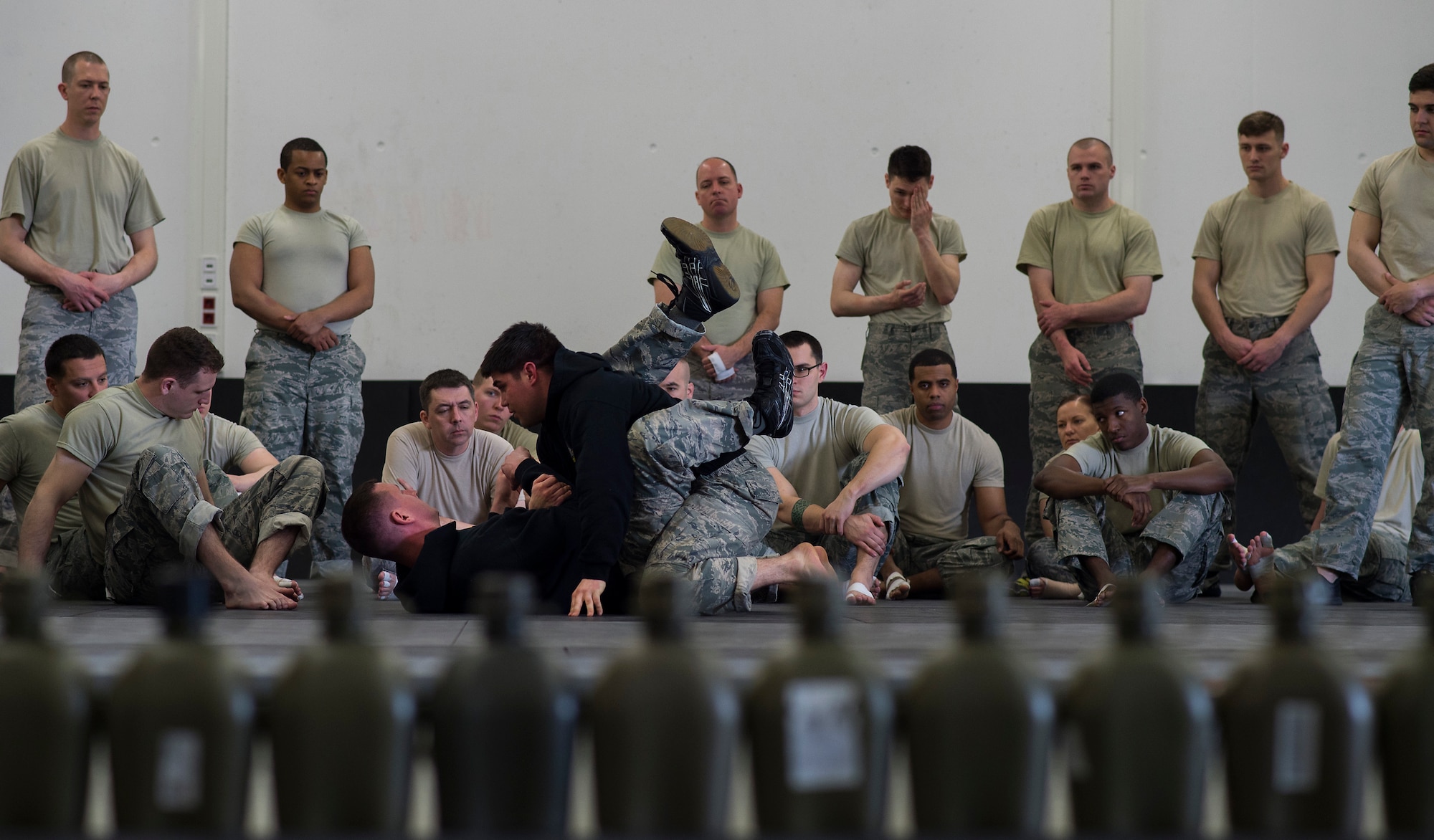 Staff Sgt. Bryan Meraz, top, 435th Security Force Squadron senior combatives instructor, and Master Sgt. Shane Spice, 435th SFS ground combat readiness training center flight chief, demonstrate ground combat moves to students during a Fly Away Security course Feb. 14, 2015, at Ramstein Air Base, Germany. The instructors teach students a variety of skills during the ten-day pre-deployment course, including hand-to-hand combat and aircraft familiarization. (U.S. Air Force photo/Senior Airman Damon Kasberg)