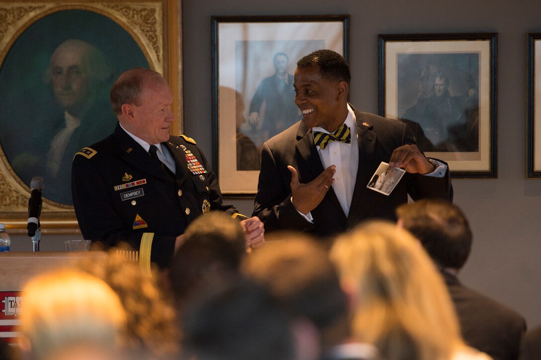 Army Gen. Martin E. Dempsey, left, chairman of the Joint Chiefs of Staff, looks on as he is introduced by a Harvard fellow before talking with national security students from Harvard University and nearby universities in Cambridge, Mass., April 22, 2015. Dempsey was on a two-day tour of the U.S. Naval Academy, U.S. Military Academy and Harvard University.