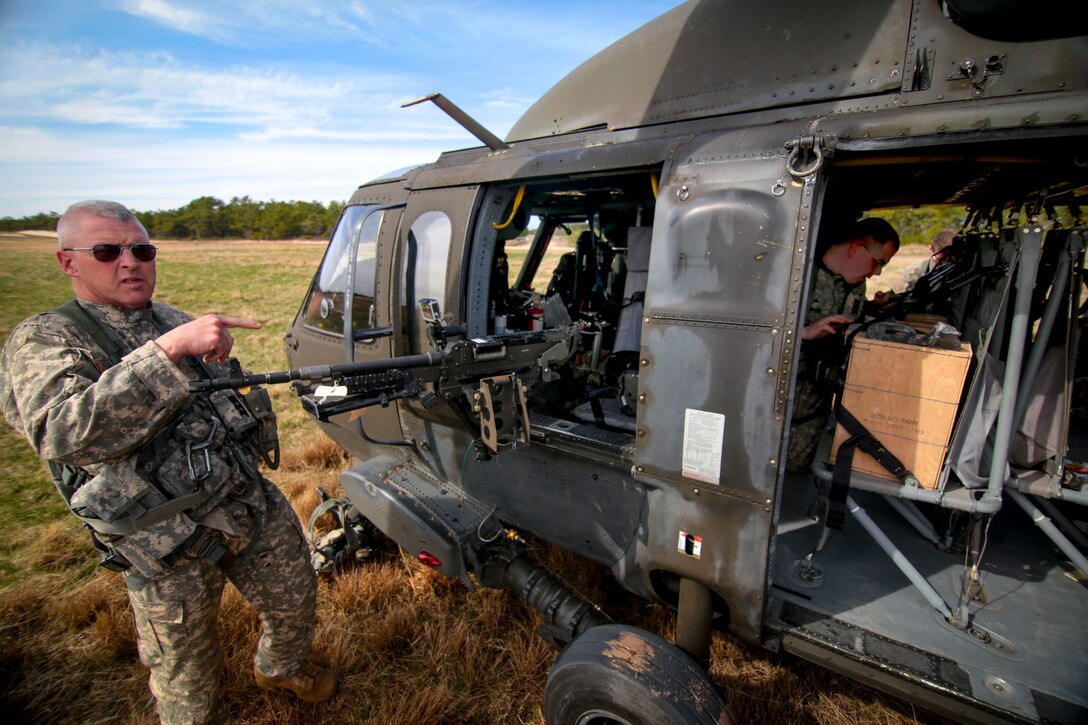 A New Jersey Army National Guard helicopter crew chief assigned to the 1st Battalion, 150th Aviation Regiment prepares for aerial gunnery training at Coyle Drop Zone at Joint Base McGuire-Dix-Lakehurst, N.J., April 16, 2015.