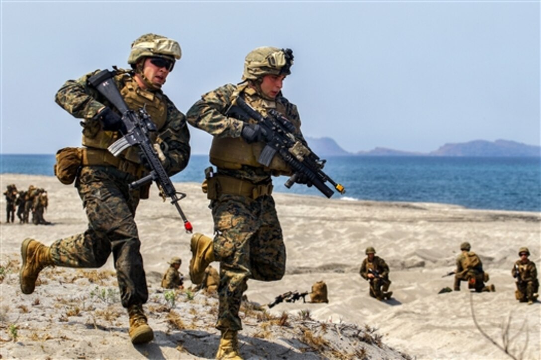 U.S. Marines quickly return to their amphibious assault vehicle to grab extra equipment for the firing line during an amphibious landing by U.S. and Philippine Marines as part of Balikatan 2015 on North Beach at the Naval Education Training Center in Zambales, Philippines, April 21, 2015.