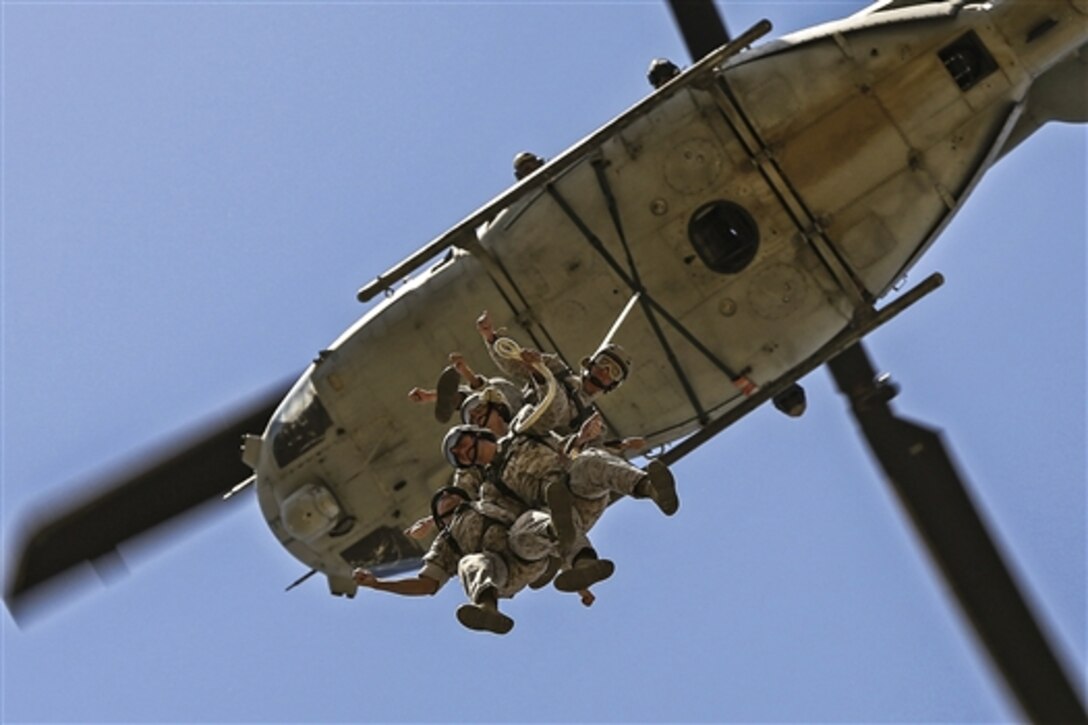 A helicopter hoists Marines into the air during insertion and extraction training on Camp Pendleton, Calif., April 17, 2015. The Marines are students of the Basic Reconnaissance Course assigned to Reconnaissance Training Company.
