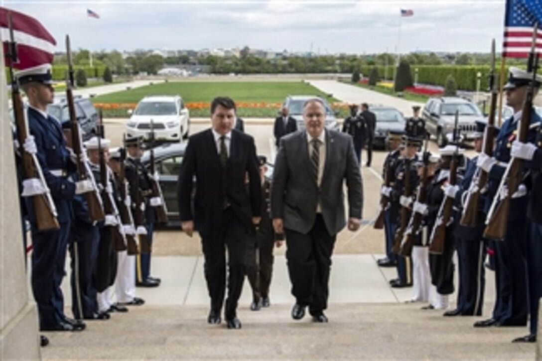 U.S. Deputy Defense Secretary Bob Work, right, hosts an honor cordon for Latvian Defense Minister Raimonds Vejonis at the Pentagon, April 23, 2015. The two defense leaders met to discuss matters of mutual importance. 