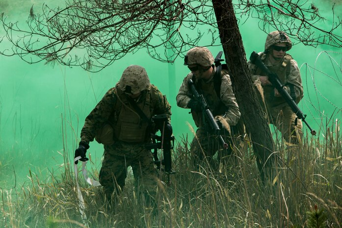 Combat engineer’s breaching team with Marine Wing Support Squadron 171, Engineer Company, combat engineer platoon, clear a route through concertina wire under the cover of green smoke during an assault on enemy position during a foot patrol and breaching drill on the Japan Ground Self-Defense Force’s Haramura Maneuver Area in Hiroshima, Japan, as part of Exercise Haramura 1-15 April 15, 2015. Haramura is a weeklong company-level training exercise was focused on reinforcing the skills Marines learned during Marine Combat Training and their Military Occupational Specialty schooling.  