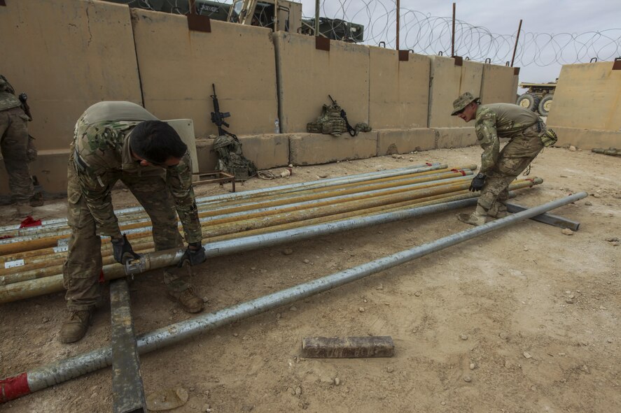U.S. Airmen attached to the 577th Expeditionary Prime Base Emergency Engineering Force Squadron move pipes as part of their mission to assess and repair a well for an emergency water supply for the Operation Inherent Resolve Building Partner Capacity Mission aboard Al-Asad Airbase, Iraq, April 11, 2015. The BPC mission will train and enable Iraqi Security Force leadership skills, medical procedures, small unit tactics, air-ground integration, and equipping and sustainment procedures. (U.S. Marine Corps Photo by Cpl. Cansin P. Hardyegritag)