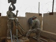 U.S. Airmen attached to the 577th Expeditionary Prime Base Emergency Engineering Force Squadron prepare to lift pipes from a broken well as part of their mission to assess and repair wells for an emergency water supply for the Operation Inherent Resolve Building Partner Capacity Mission aboard Al-Asad Airbase, Iraq, April 11, 2015. The BPC mission will train and enable Iraqi Security Force leadership skills, medical procedures, small unit tactics, air-ground integration, and equipping and sustainment procedures. (U.S. Marine Corps Photo by Cpl. Cansin P. Hardyegritag)