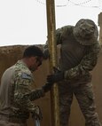 U.S. Air Force Master Sgt. Kent Hinshaw and Staff Sgt. Andrew Modesto, Water and Fuel system specialists attached to the 577th Expeditionary Prime Base Emergency Engineering Force Squadron, lift pipes out of a well as part of their mission to assess and repair wells for an emergency water supply for the Operation Inherent Resolve Building Partner Capacity Mission aboard Al-Asad Airbase, Iraq, April 11, 2015. The BPC mission will train and enable Iraqi Security Force leadership skills, medical procedures, small unit tactics, air-ground integration, and equipping and sustainment procedures. (U.S. Marine Corps Photo by Cpl. Cansin P. Hardyegritag)
