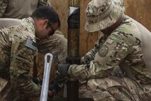 U.S. Air Force Master Sgt. Kent Hinshaw and Staff Sgt. Andrew Modesto, water and fuel system specialists attached to the 577th Expeditionary Prime Base Emergency Engineering Force Squadron, lift pipes out of a well as part of their mission to assess the capability of the well for an emergency water supply for the Operation Inherent Resolve Building Partner Capacity Mission aboard Al-Asad Airbase, Iraq, April 11, 2015. The BPC mission will train and enable Iraqi Security Force leadership skills, medical procedures, small unit tactics, air-ground integration, and equipping and sustainment procedures. (U.S. Marine Corps Photo by Cpl. Cansin P. Hardyegritag)