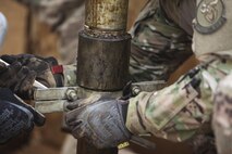 U.S. Air Force Master Sgt. Kent Hinshaw and Staff Sgt. Andrew Modesto, water and fuel system specialists attached to the 577th Expeditionary Prime Base Emergency Engineering Force Squadron, decouple pipes of a well as part of their mission to assess the well’s capability for an emergency water supply for the Operation Inherent Resolve Building Partner Capacity Mission aboard Al-Asad Airbase, Iraq, April 11, 2015. The BPC mission will train and enable Iraqi Security Force leadership skills, medical procedures, small unit tactics, air-ground integration, and equipping and sustainment procedures. (U.S. Marine Corps Photo by Cpl. Cansin P. Hardyegritag)
