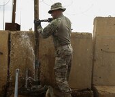 U.S. Air Force Master Sgt. Kent Hinshaw, a water and fuel system specialist attached to the 577th Expeditionary Prime Base Emergency Engineering Force Squadron, lifts a pipe out of a well as part of his mission to assess the well for an emergency water supply for the Operation Inherent Resolve Building Partner Capacity Mission aboard Al-Asad Airbase, Iraq, April 11, 2015. The BPC mission will train and enable Iraqi Security Force leadership skills, medical procedures, small unit tactics, air-ground integration, and equipping and sustainment procedures. (U.S. Marine Corps Photo by Cpl. Cansin P. Hardyegritag)