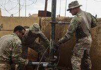 U.S. Air Force Master Sgts. Philip Deckard and Kent Hinshaw and Staff Sgt. Andrew Modesto, water and fuel system specialists attached to the 577th Expeditionary Prime Base Emergency Engineering Force Squadron, lift a pipe out of a well as part of their mission to assess the well for an emergency water supply for the Operation Inherent Resolve Building Partner Capacity Mission aboard Al-Asad Airbase, Iraq, April 11, 2015. The BPC mission will train and enable Iraqi Security Force leadership skills, medical procedures, small unit tactics, air-ground integration, and equipping and sustainment procedures. (U.S. Marine Corps Photo by Cpl. Cansin P. Hardyegritag)