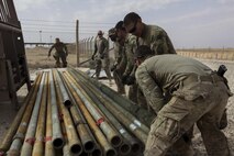 U.S. Airmen attached to the 577th Expeditionary Prime Base Emergency Engineering Force Squadron move and organize pipes as part of their mission to assess the well for an emergency water supply for the Operation Inherent Resolve Building Partner Capacity Mission aboard Al-Asad Airbase, Iraq, April 11, 2015. The BPC mission will train and enable Iraqi Security Force leadership skills, medical procedures, small unit tactics, air-ground integration, and equipping and sustainment procedures. (U.S. Marine Corps Photo by Cpl. Cansin P. Hardyegritag)