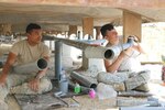 Spc. Zenas Sigrah and Spc. Kevin Lucas work on installing pipe for plumbing in the support trailers recently at Camp Arifjan, Kuwait. The project was part of an effort to expand housing units for Soldiers assigned to Camp Arifjan. The base has seen its numbers increase with the drawdown in Afghanistan and the beginning of Operation Inherent Resolve in Iraq.