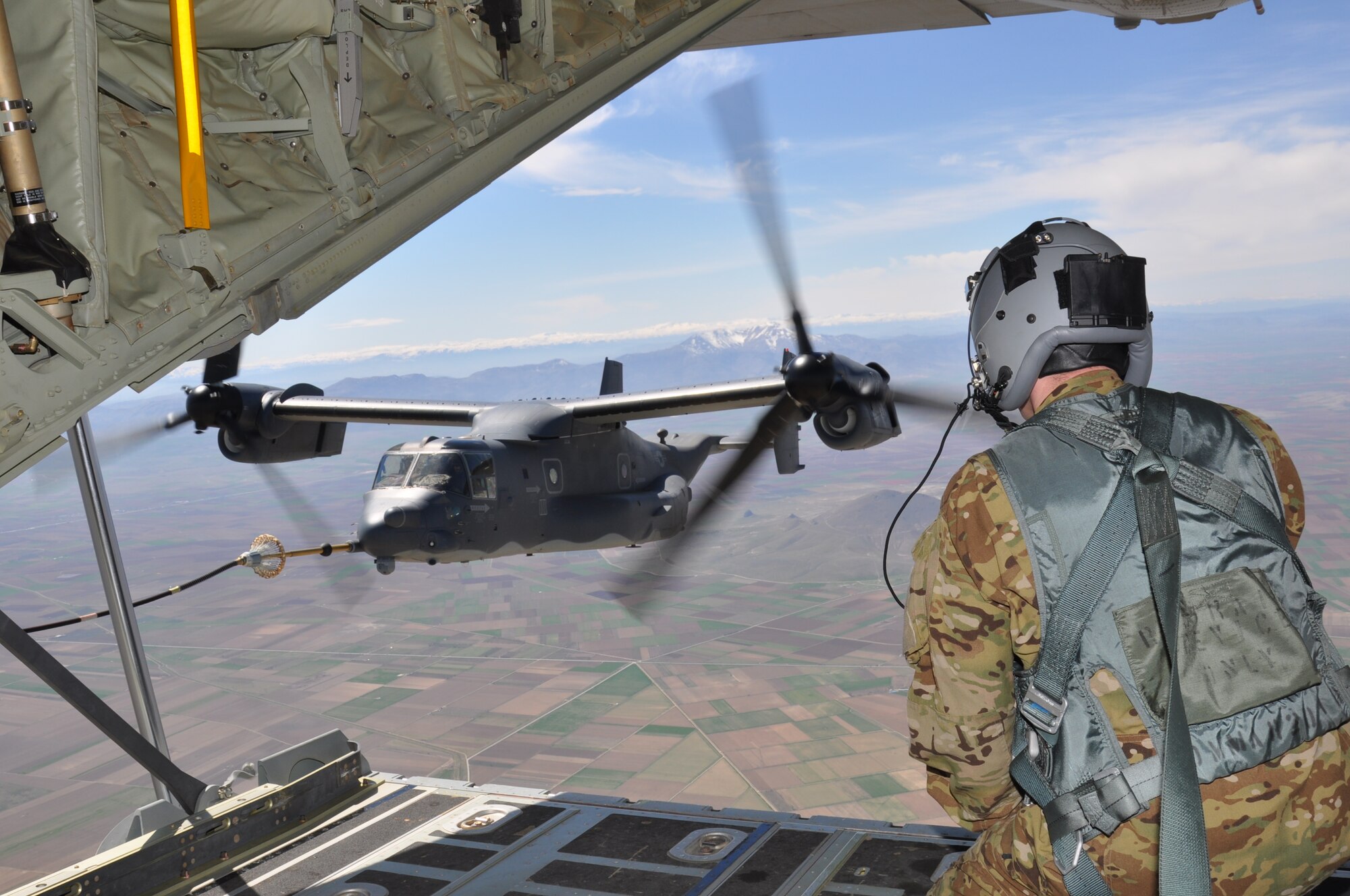 A U.S. Air Force aircraft loadmaster monitors the refueling process between an MC-130J Commando II and a CV-22B Osprey April 6, 2015, while flying over Konya, Turkey. The flight was part of ISIK, an international combat search and rescue event, which focused its training scenarios on two skillsets: personnel recovery and airfield establishment and control. (U.S. Air Force photo by Capt. Laura Balch)