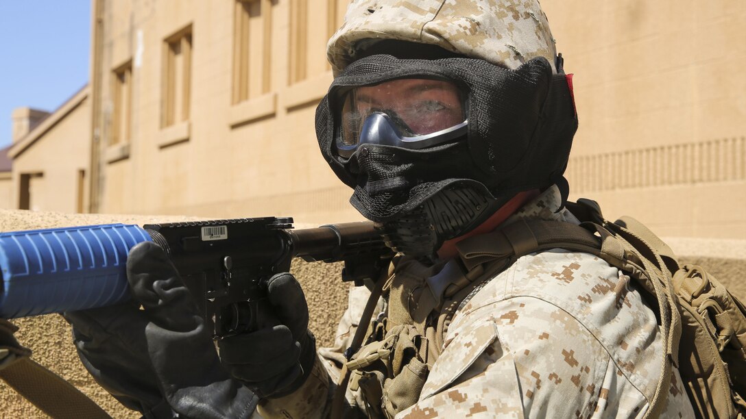 Pfc. Mason Woodford, a rifleman with Charlie Company, 1st Battalion, 8th Marine Regiment, posts security for his fire team as they approach a possible improvised explosive threat during a training exercise aboard Marine Corps Base Camp Lejeune, North Carolina, April 22, 2015. The Marines maintained security at all times during their patrol through an urban training town in case they faced any unexpected enemy attacks. They wore masks to protect their faces while using simulated rounds to suppress the mock-enemies. (U.S. Marine Corps photo by Cpl. Kaitlyn Klein/Released)