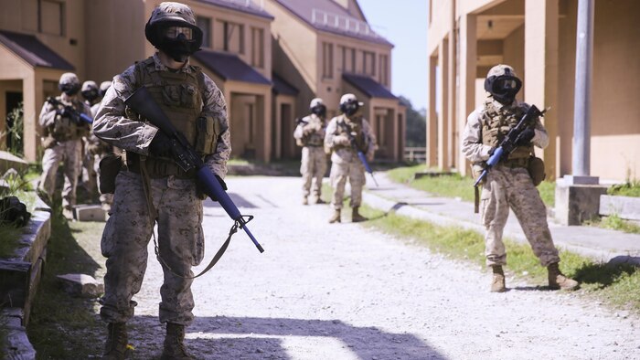 Marines with Charlie Company, 1st Battalion, 8th Marine Regiment, prepare to begin their patrol through an urban training town during a training exercise aboard Marine Corps Base Camp Lejeune, North Carolina, April 22, 2015. The Marines kept their heads on a swivel, constantly observing the areas around them, and clearing each window and door they passed. They wore masks to protect their faces while using simulated rounds to suppress the mock-enemies. (U.S. Marine Corps photo by Cpl. Kaitlyn Klein/Released)