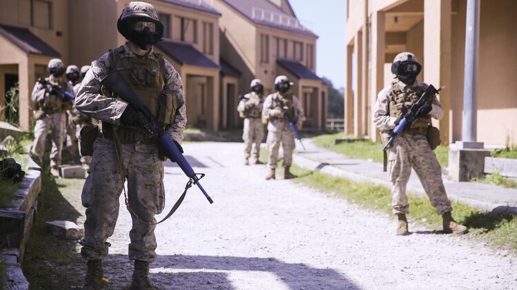 Marines with Charlie Company, 1st Battalion, 8th Marine Regiment, prepare to begin their patrol through an urban training town during a training exercise aboard Marine Corps Base Camp Lejeune, North Carolina, April 22, 2015. The Marines kept their heads on a swivel, constantly observing the areas around them, and clearing each window and door they passed. They wore masks to protect their faces while using simulated rounds to suppress the mock-enemies. (U.S. Marine Corps photo by Cpl. Kaitlyn Klein/Released)
