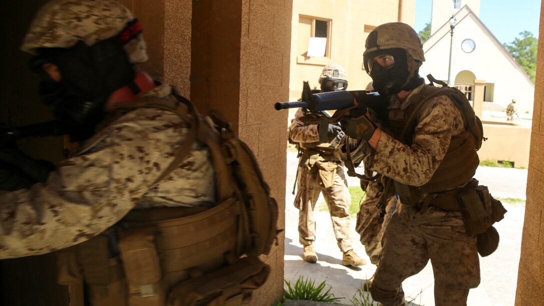 Marines with Charlie Company, 1st Battalion, 8th Marine Regiment, maintains control of his weapon as he enters an un-cleared room during a training exercise aboard Marine Corps Base Camp Lejeune, North Carolina, April 22, 2015. The Marines arranged themselves into a single-file line formation as they approached windows and open doors before splitting off inside and presenting their rifles at each angle of the room in case of an unexpected enemy encounter. They wore masks to protect their faces while using simulated rounds to suppress the mock-enemies. (U.S. Marine Corps photo by Cpl. Kaitlyn Klein/Released)
