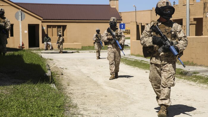 Marines with Charlie Compnay, 1st Battalion, 8th Marine Regiment, conduct patrols through an urban training town during a counter improvised explosive device training exercise, aboard Marine Corps Base Camp Lejeune, North Carolina, April 22, 2015. The Marines were faced with the threat of simulated improvised explosive devices and mock-enemies throughout their patrols. They wore masks to protect their faces while using simulated rounds to suppress the enemies. (U.S. Marine Corps photo by Cpl. Kaitlyn Klein/Released)