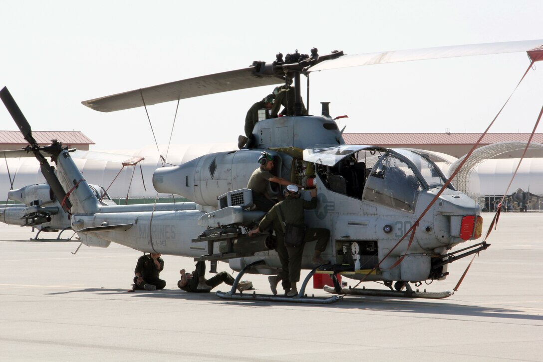 Aircraft mechanic Marines with Marine Aviation Weapons and Tactics Squadron 1 inspect an AH-1W Super Cobra helicopter during a routine maintenance inspection Weapons and Tactics Instructor course 2-15 aboard Marine Corps Air Station Yuma, Arizona., April 22, 2015. The maintenance that they provide ensures all pilot candidates complete every mission safely. WTI is a seven-week course hosted by MAWTS-1 that provides advanced tactical training to certify Marine pilots as weapons and tactics instructors, preparing them to return to the fleet and serve in key training officer billets. (U.S. Marine Corps photo by Sgt. Cody Haas)