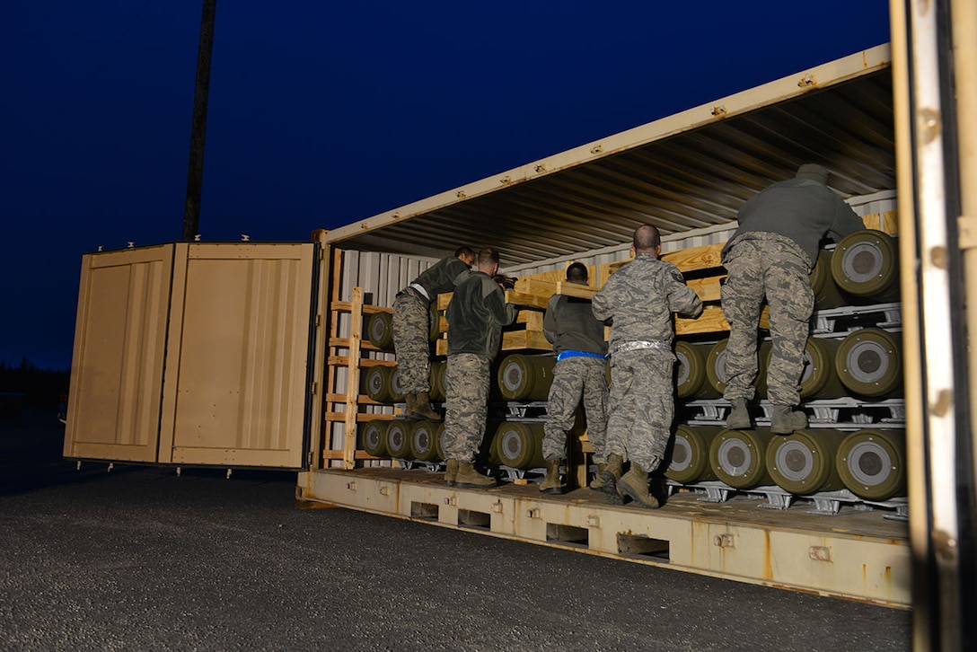 The first load of the ammunition barge arrives at Joint Base Elmendorf-Richardson, Alaska, April 15, 2015. Contracted forklift operators use their skills to unload each container, which weighs between 20,000 and 40,000 pounds. After the items are offloaded from the trucks, the ammunition inspection team standing by opens the containers and inspects the ammunition before storing it in earth-covered bunkers. (U.S. Air Force photo/Airman 1st Class Kyle Johnson)