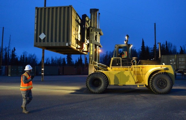 The first load of the ammunition containers arrive on Joint Base Elmendorf-Richardson, Alaska, April 15, 2015. Contracted forklift operators use their skills to unload each container, which weights between 20,000 and 40,000 pounds. After they are offloaded from the trucks, the ammunition inspection team standing by opens the containers and inspects the ammunition before storing them into earth-covered igloos. (U.S. Air Force Photo/Airman 1st Class Kyle Johnson)