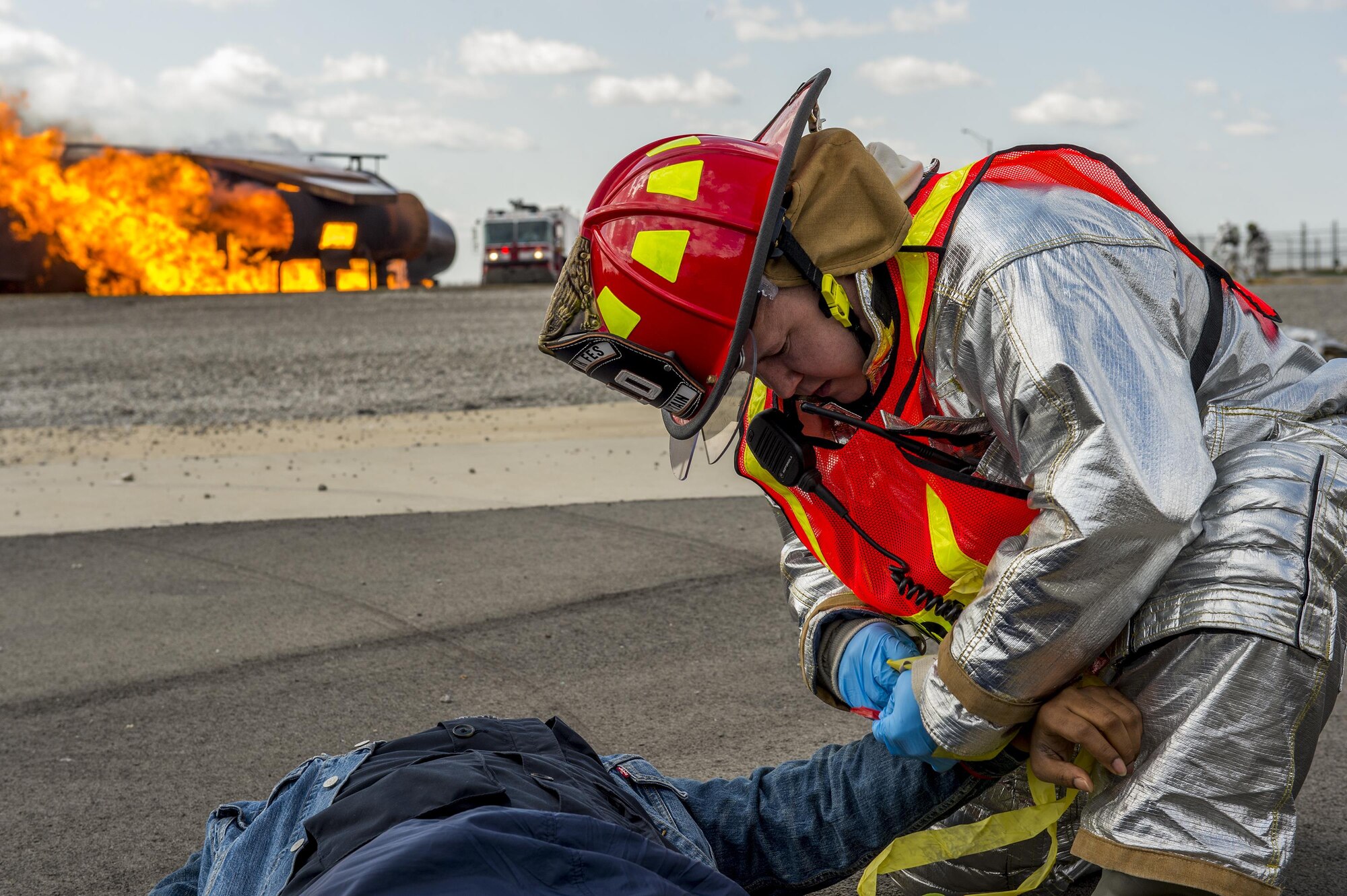 John West, a firefighter with the 910th Civil Engineer Squadron fire department here, places a yellow band around a simulated victim’s arm during a multi-agency anti-hijacking exercise held here, April 24, 2015. The yellow band helps emergency response personnel prioritize victims for treatment based on injury severity. In the background, other 910th firefighters fight a blaze on a training aircraft simulating a commercial aircraft after terrorists detonate an explosive device. Participating agencies included the Western Reserve Port Authority, Youngstown-Warren Regional Airport, local law enforcement and fire departments, the Federal Bureau of Investigation, the Federal Aviation Administration and the Air Force Reserve. (U.S. Air Force photo/Eric M. White)