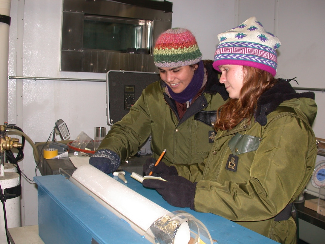 CRREL summer students Amanda Smith and Elyse Williamson examine an ice core from Greenland.