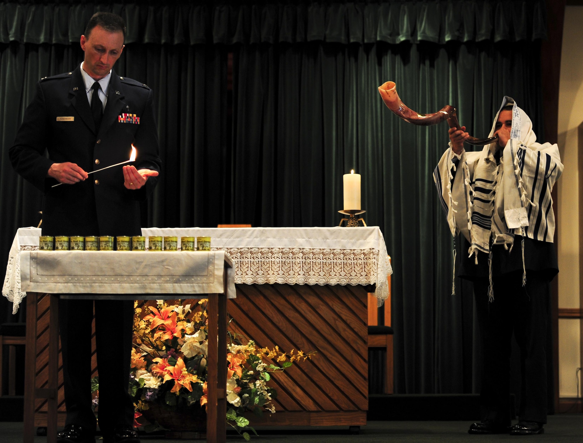 Master Sgt. Michael Felan, 1st Special Operations Civil Engineer Squadron NCO in charge of heavy equipment, plays the Shofar, while Chaplain Mark Hunsinger lights candles, during the Holocaust memorial service at the base chapel on Hurlburt Field Fla., April 22, 2015. The memorial was held as a remembrance to honor those who lost their lives during the Holocaust. (U.S. Air Force photo by Senior Airman Meagan Schutter)