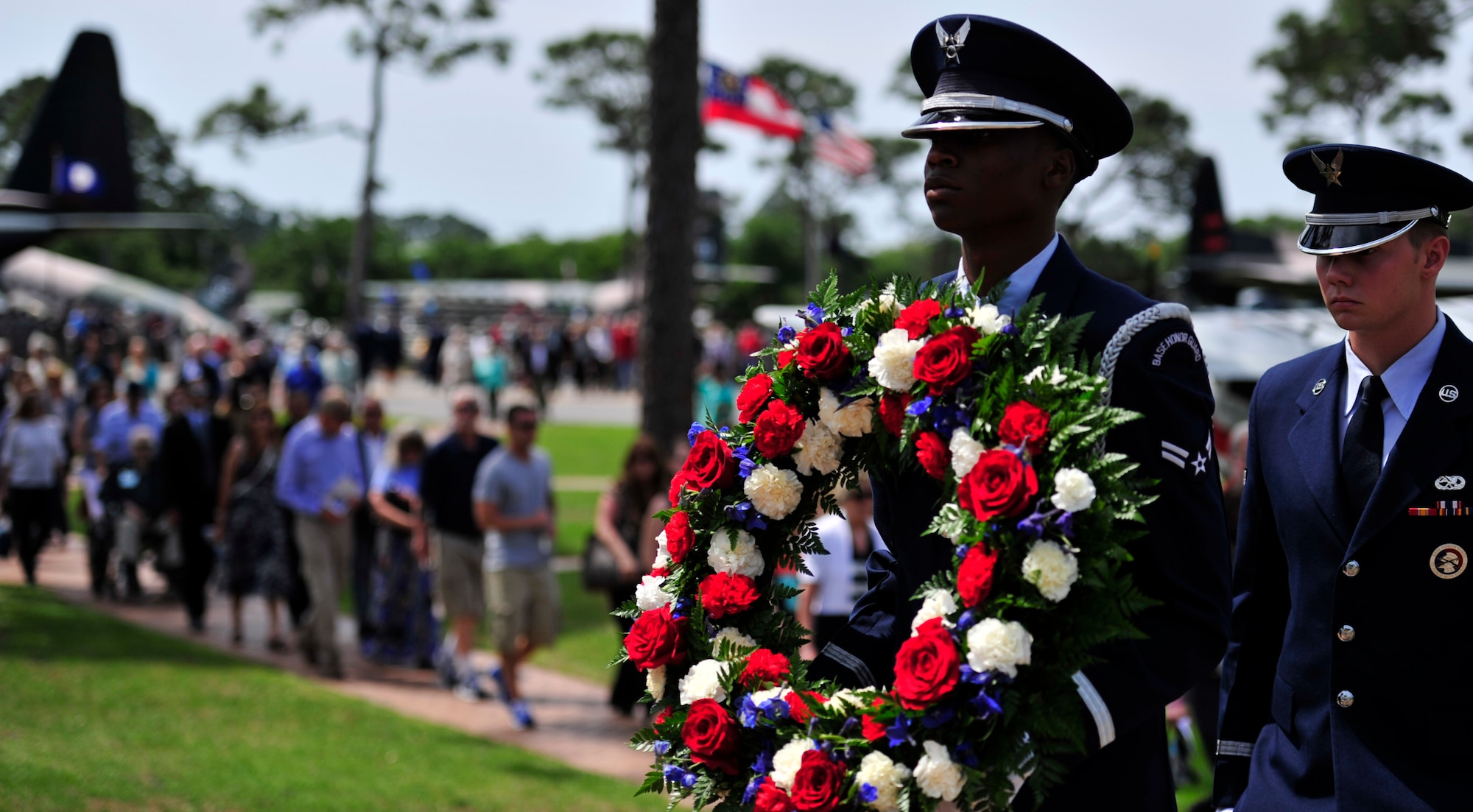 An honor guardsman carries a rose wreath from the air park to the base chapel during the Operation Eagle Claw memorial ceremony on Hurlburt Field, Fla., April 24, 2015.  The rose wreath honored Maj. Richard Bakke, Maj. Harold Lewis Jr., Tech. Sgt. Joel C. Mayo, Maj. Lyn McIntosh and Capt. Charles McMillan II, all from the 8th Special Operations Squadron, as well as Marine Sgt. John Harvey, Cpl. George Holmes Jr. and Staff Sgt. Dewey Johnson, who lost their lives during the operation. (U.S. Air Force photo/Staff Sgt. Melanie Holochwost)
