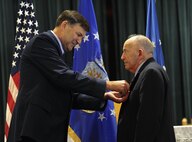Lt. Gen. Brad Heithold, commander Air Force Special Operations Command, pins the Defense Superior Service Medal on Retired Air Force Col. Thomas Wicker at the base chapel on Hurlburt Field, Fla., April 24, 2015. (U.S. Air Force photo by Airman Kai White)