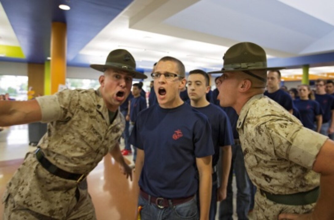 A Poolee from Recruiting Sub-Station Mid-Cities, RS Fort Worth, gets told to move faster by two drill instructors during the annual pool function family night at Brewer High School, April 22, 2014. More than 150 poolees from the Fort Worth metropolitan area attended a family night to prepare them for Marine Corps recruit training.