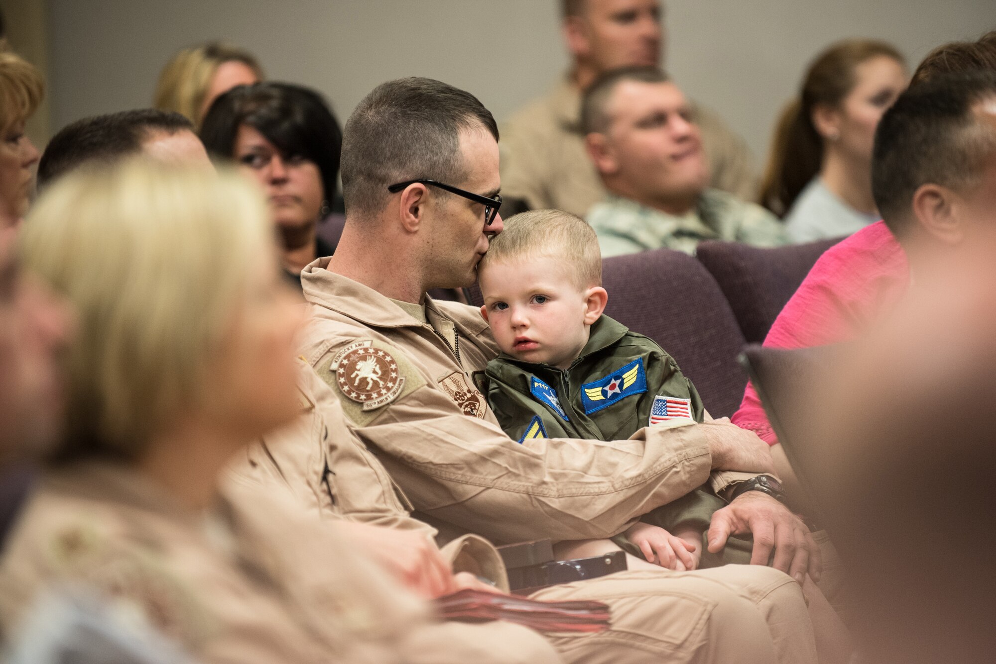 Tech. Sgt. Paul Jones, a C-130 loadmaster in the 123rd Airlift Wing, and his son, Jonathan Paul Jones, attend a briefing at the Kentucky Air National Guard Base in Louisville, Ky., April 24, 2015, prior to Jones' deployment to an undisclosed air base in the Persian Gulf region. Jones and more than 40 other Kentucky Air Guardsmen comprise the third rotation of 123rd Airmen to deploy to the base since February. They will be flying airlift missions throughout the U.S. Central Command Area of Responsibility in support of Operation Freedom's Sentinel, which provides military training and counterterrorism capabilities in Afghanistan. (U.S. Air National Guard photo by Maj. Dale Greer)