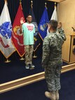 Shawn McGrew, son of Master Sgt. Shanette Jean, 47th Medical Group dental flight chief, takes his first “step into the blue” as he raises his hand and takes the Oath of Enlistment in San Antonio Texas, March 5, 2015. April is the Month of the Military Child, a time to honor the unique contributions and sacrifices military children make on behalf of America. (Courtesy Photo)