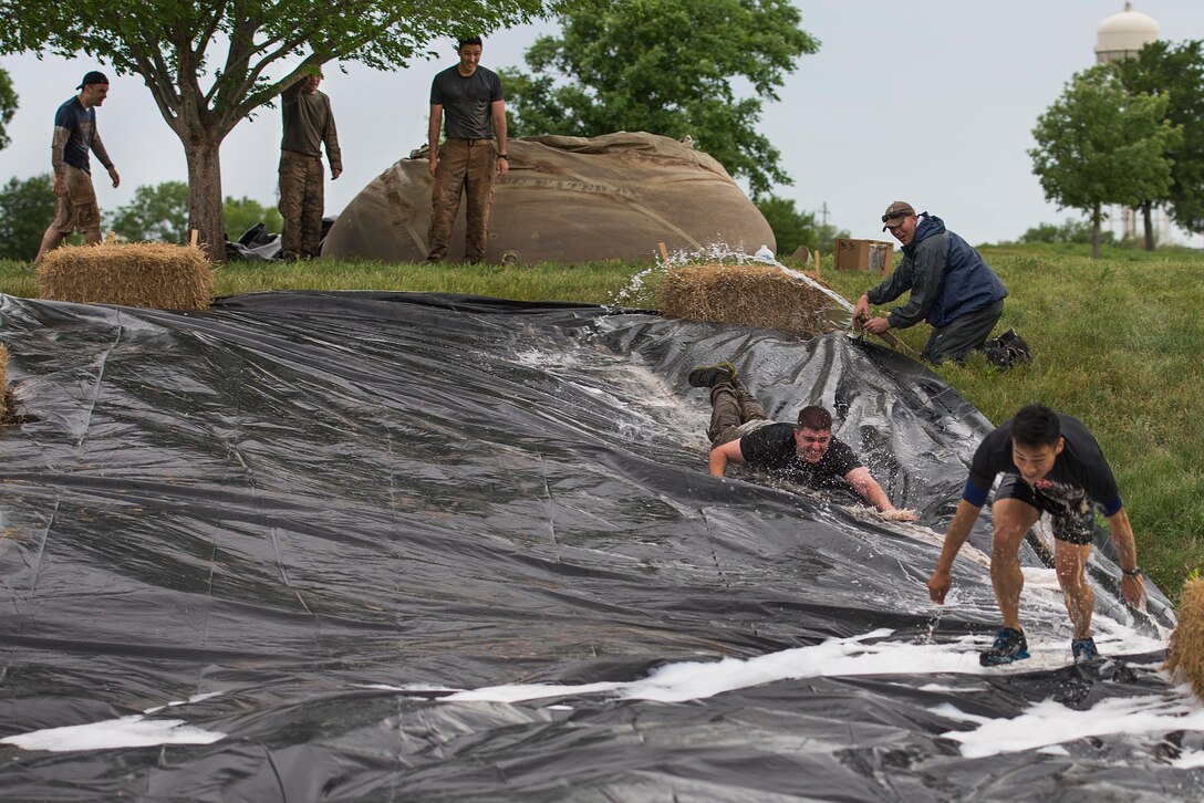 U.S. Air Force Airmen slide down a slippery slope at the Sheppard Air Force Base, Texas, Combat Barbeque, April 24, 2015. The barbeque obstacle course had 12 obstacles with 30 teams that participated in the 5k race. The 82nd Security Forces Squadron took the first place title with the 80th Flying Training Wing at a close second. (U.S. Air Force photo by Senior Airman Kyle Gese/Released)