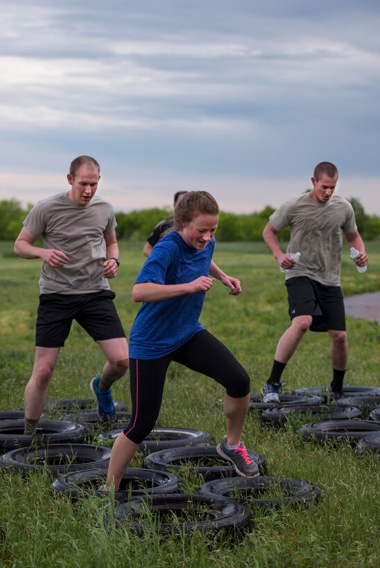 U.S. Air Force Airmen from Sheppard Air Force Base, Texas, maneuver through a tire obstacle during the base-wide Combat Barbeque, April 24, 2015. The barbeque brought more than 1,000 Airmen together; building teams and strengthening morale to bolster a professional Airmen culture. (U.S. Air Force photo by Senior Airman Kyle Gese/Released)