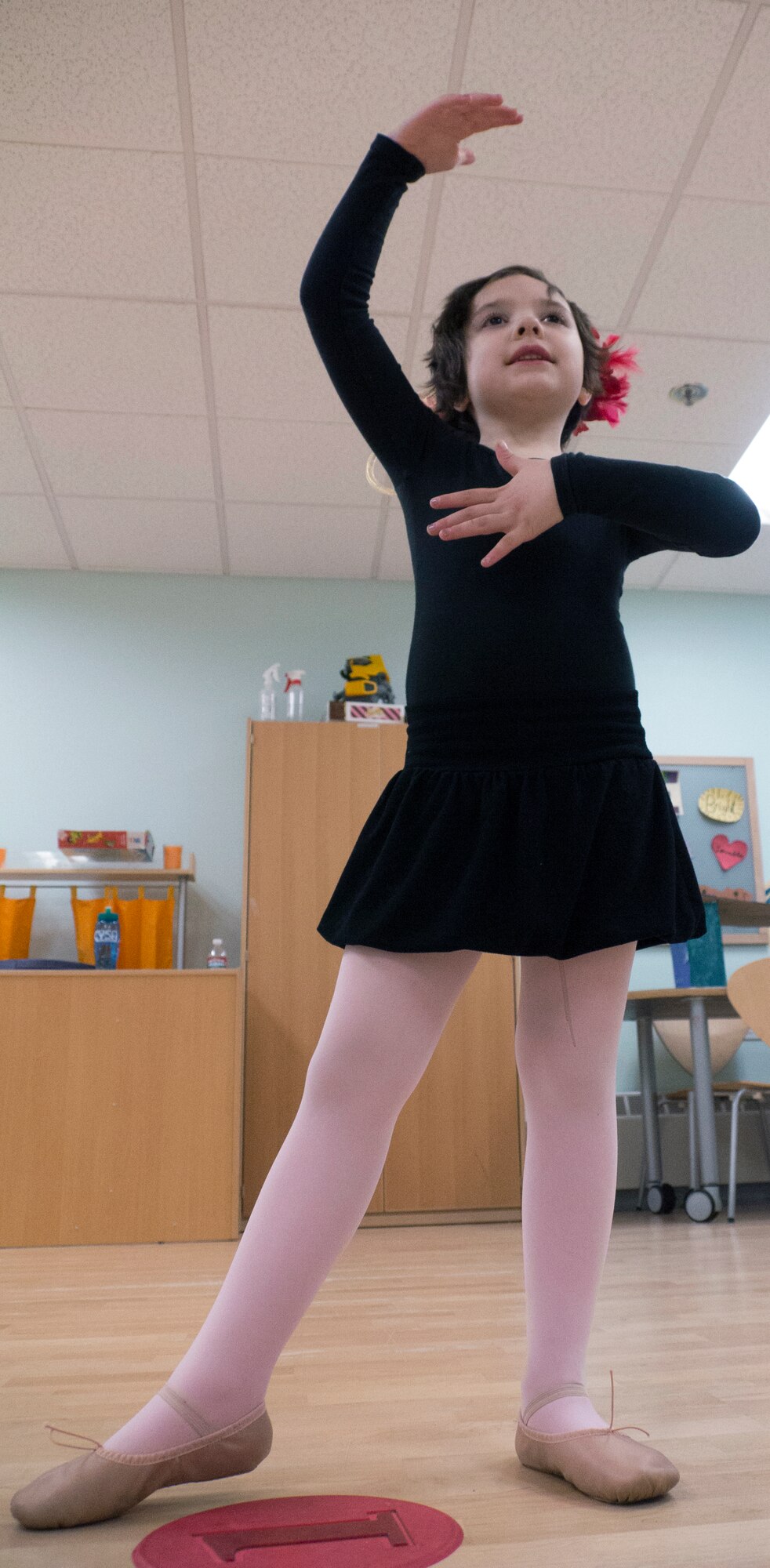 Audreena Smith, 7, daughter of Master Sgt. Thomas Smith, 673d Civil Engineer Squadron first sergeant, takes the Cecchetti fifth position during ballet class on Joint Base Elmendorf-Richardson, Alaska, April 16, 2015. Smith was practicing her ballet positions during rehearsal for an upcoming recital May 3, 2015. Ballet is one of many classes offered by the Youth Instructional Program on JBER. Other classes include, but are not limited to, gymnastics, music and hip-hop dancing. (U.S. Air Force photo/Airman 1st Class Tammie Ramsouer)